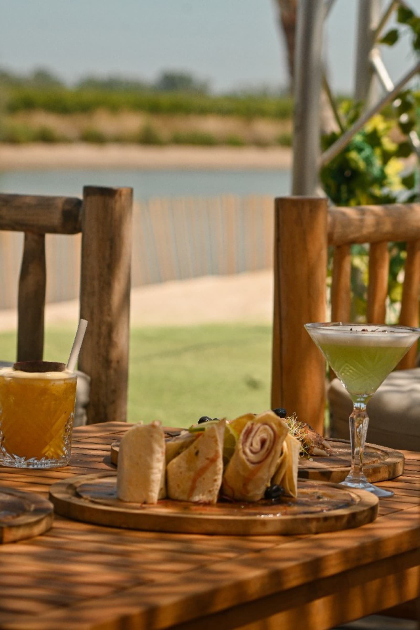 Planches charcuterie ibérique et cocktails sur table en bois en terrasse
